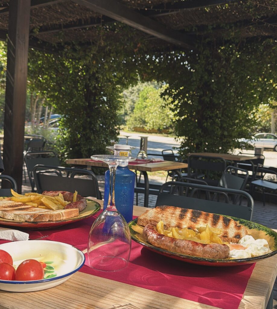 Mesa en la terraza de Masia Roca Vell con parrillada de carnes y patatas